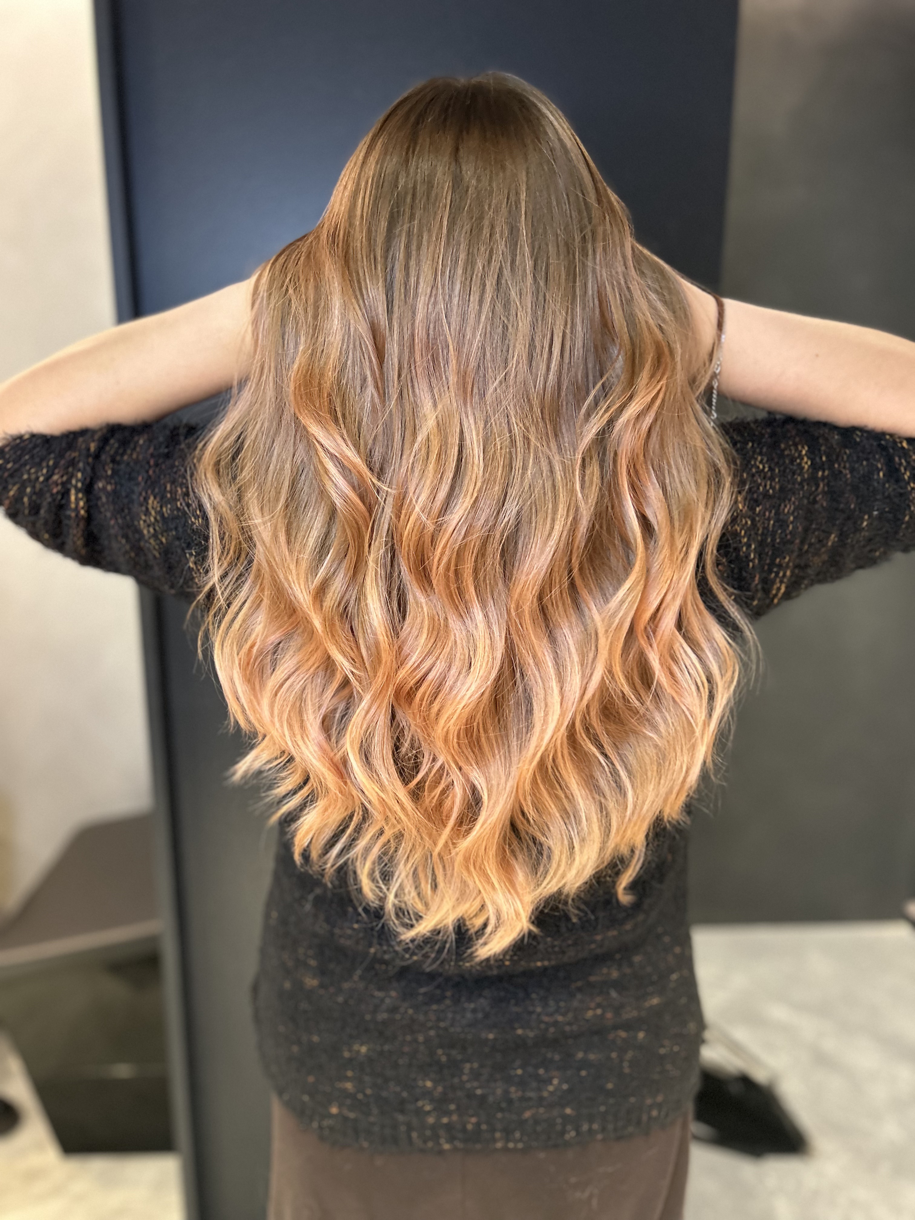 Extension e balayage ramato dorato su capelli lunghi mossi, vista completa