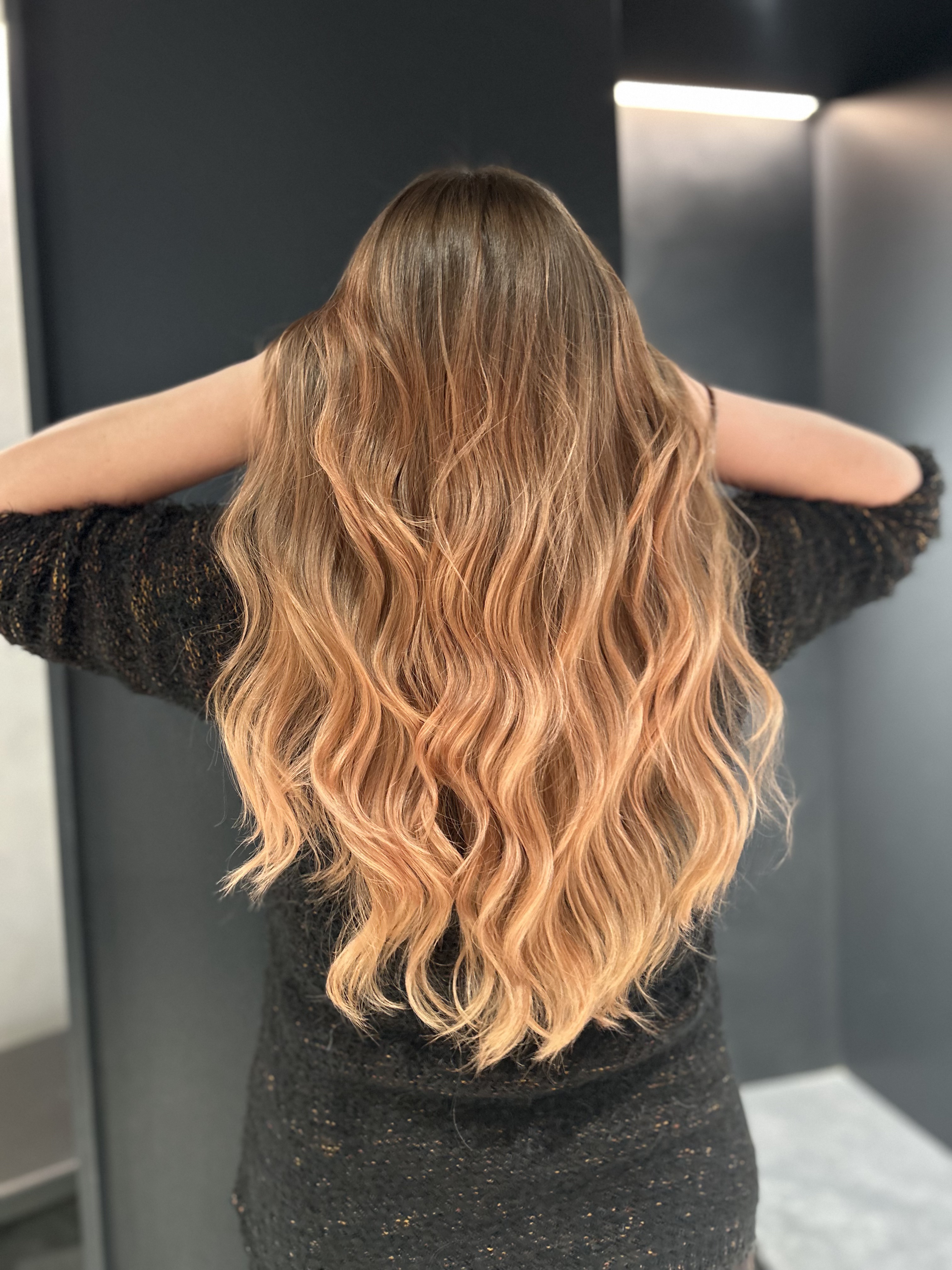 Risultato extension nel salone Marco Ambrosi: capelli lunghi mossi con balayage ramato dorato